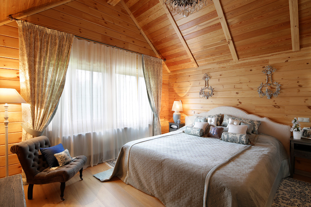 Bild på ett lantligt sovrum, med beige väggar och mellanmörkt trägolv