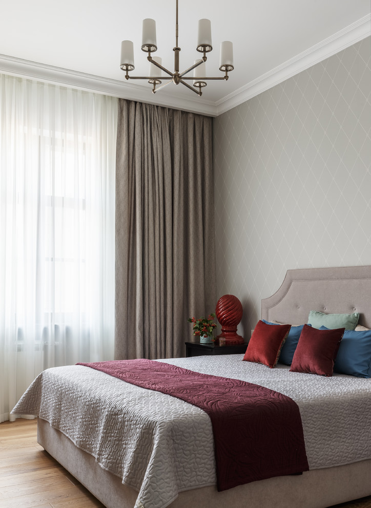 На фото: спальня в стиле неоклассика (современная классика) с серыми стенами, паркетным полом среднего тона и коричневым полом с