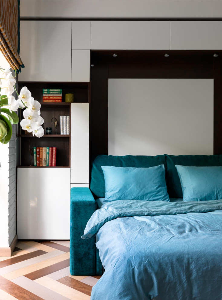 Imagen de dormitorio principal bohemio pequeño con paredes blancas, suelo de madera en tonos medios, suelo multicolor y ladrillo