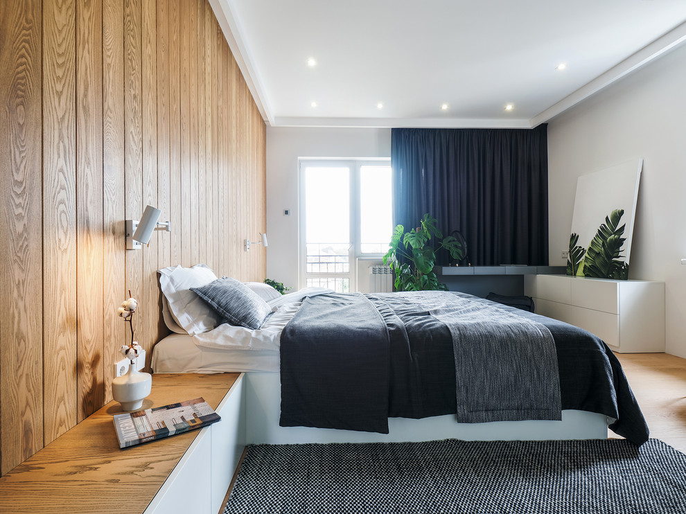 Immagine di una camera da letto minimal con pareti bianche, parquet chiaro e pavimento beige