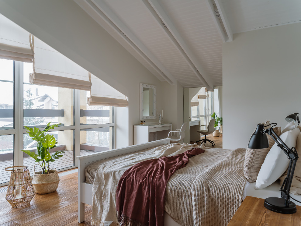 Cette photo montre une grande chambre parentale scandinave avec un mur blanc, un sol en bois brun et poutres apparentes.