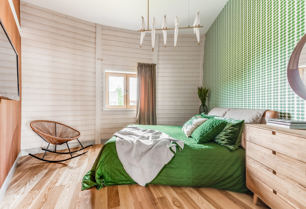 Immagine di una camera matrimoniale contemporanea con pareti verdi, pavimento in legno massello medio e pavimento marrone