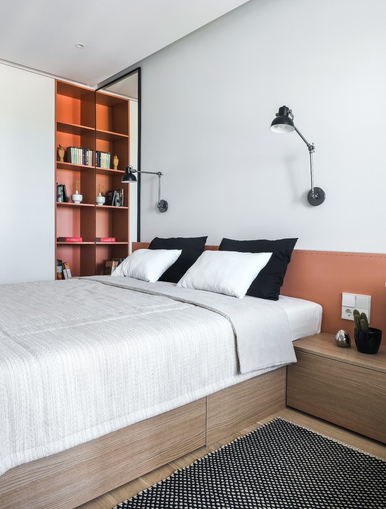 Esempio di una camera da letto design con pareti bianche, parquet chiaro e pavimento beige