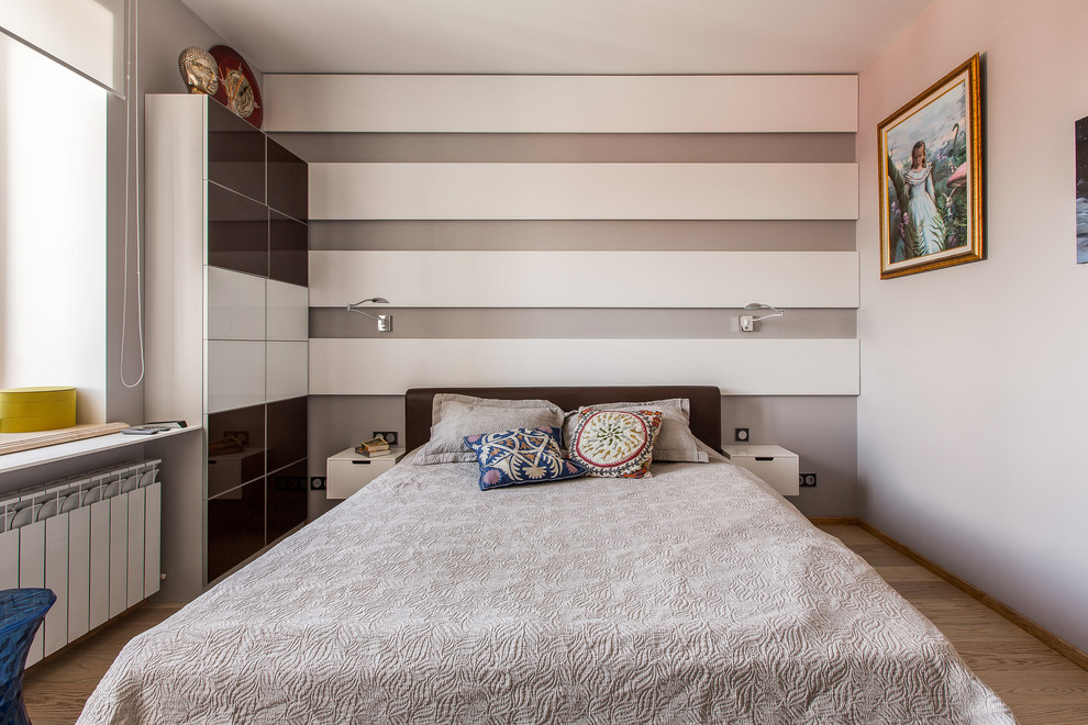 Foto på ett funkis sovrum, med grå väggar och ljust trägolv
