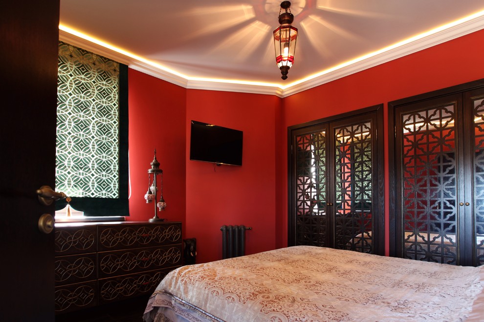 Ispirazione per una camera matrimoniale etnica con pareti rosse e pavimento marrone
