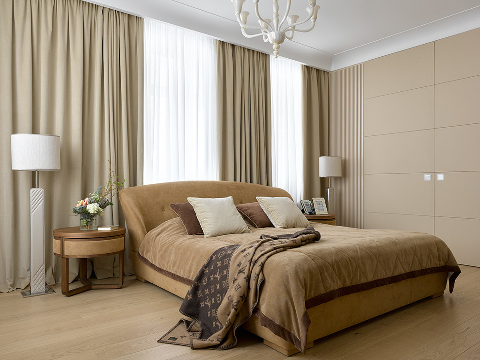 Imagen de dormitorio principal contemporáneo con paredes beige, suelo de madera clara y suelo beige