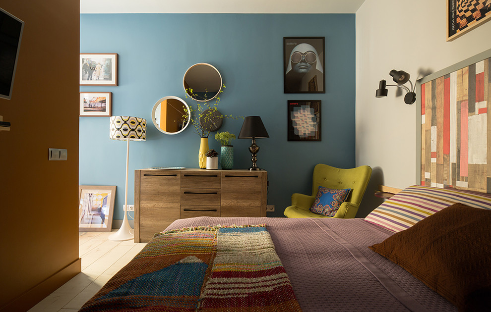 Modelo de dormitorio bohemio con paredes azules y suelo de madera clara
