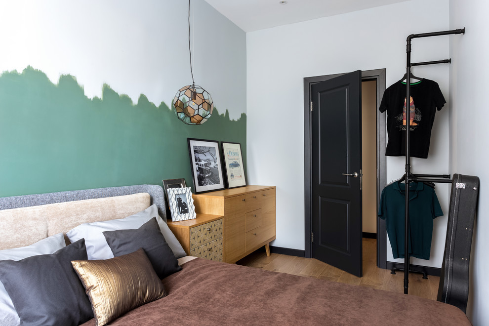 На фото: маленькая хозяйская спальня в скандинавском стиле с зелеными стенами, коричневым полом и полом из ламината для на участке и в саду с