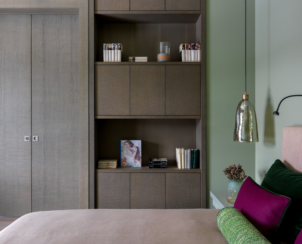 Exemple d'une chambre tendance de taille moyenne avec un mur vert, un sol en bois brun et un sol marron.