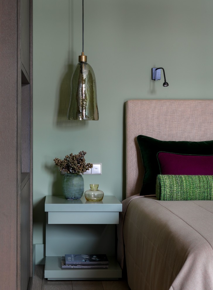 На фото: спальня среднего размера в современном стиле с зелеными стенами, паркетным полом среднего тона и коричневым полом