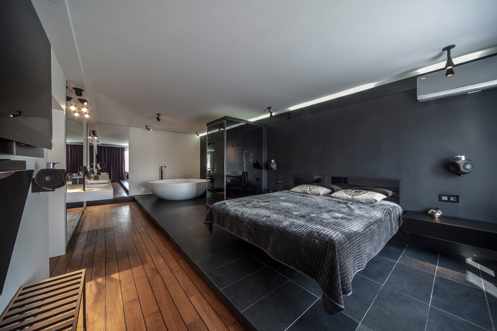 На фото: большая хозяйская спальня в современном стиле с черными стенами, темным паркетным полом и коричневым полом с
