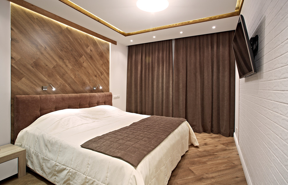 Esempio di una piccola camera matrimoniale design con pareti bianche e pavimento in legno massello medio