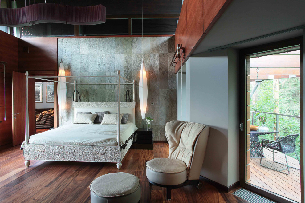 Esempio di un'ampia e In mansarda camera da letto design con pareti grigie, parquet scuro, pavimento marrone e pareti in legno