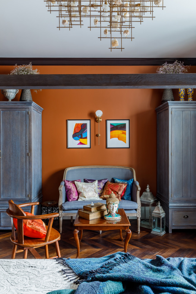 Cette photo montre une grande chambre parentale méditerranéenne avec un mur orange, un sol en bois brun et un sol marron.