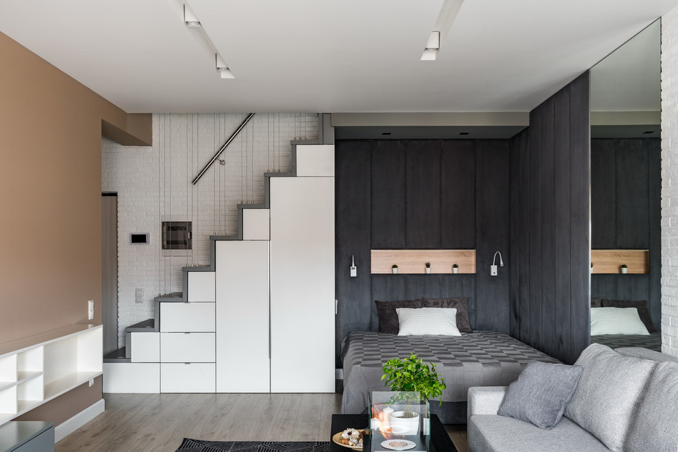 This is an example of a small scandinavian master and grey and black bedroom in Saint Petersburg with black walls, light hardwood flooring, beige floors and feature lighting.