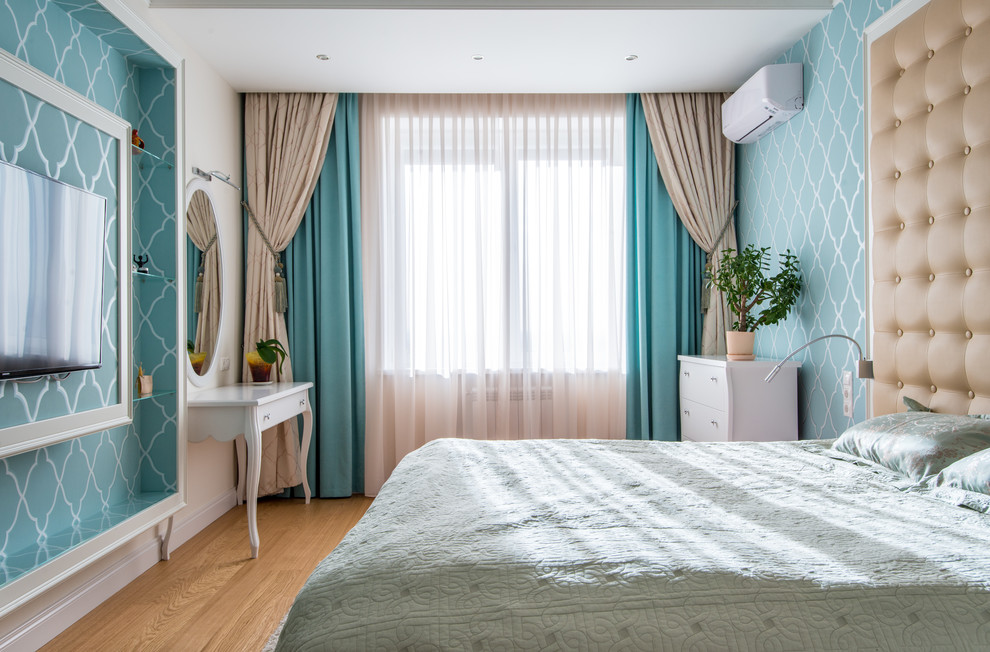 Modelo de dormitorio principal con paredes azules, suelo de madera en tonos medios y suelo beige