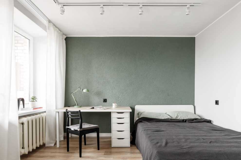 Свежая идея для дизайна: маленькая спальня в современном стиле с зелеными стенами, полом из ламината и коричневым полом для на участке и в саду - отличное фото интерьера