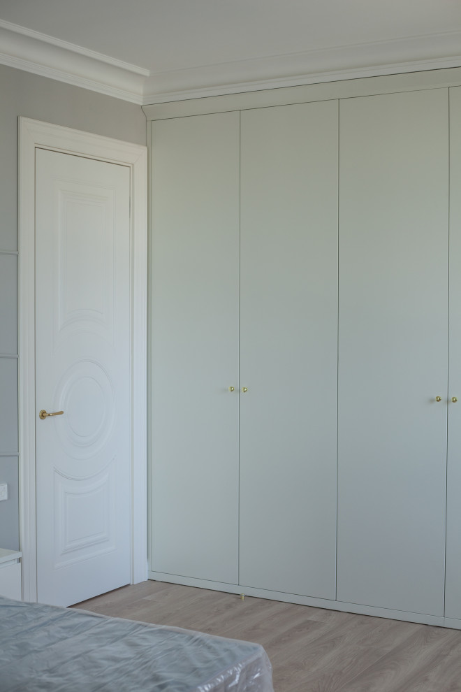 Aménagement d'une chambre parentale classique de taille moyenne avec un mur gris, sol en stratifié, aucune cheminée et un sol beige.