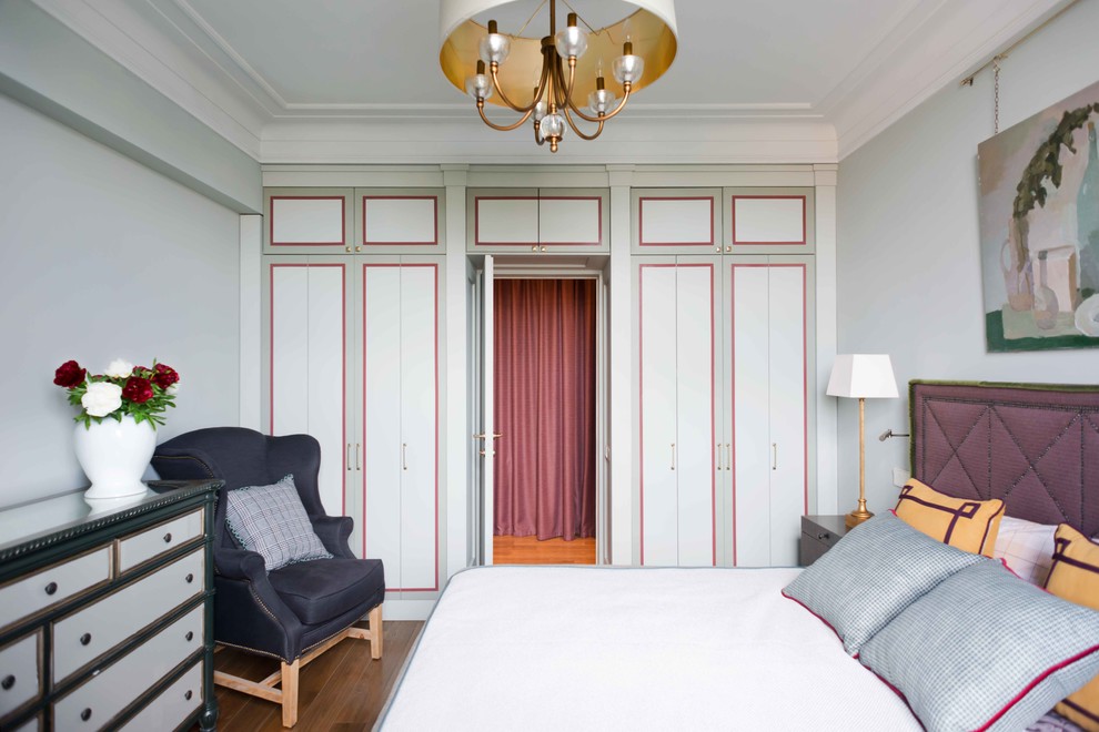 Immagine di una camera matrimoniale chic con pareti grigie, pavimento in legno massello medio e pavimento marrone