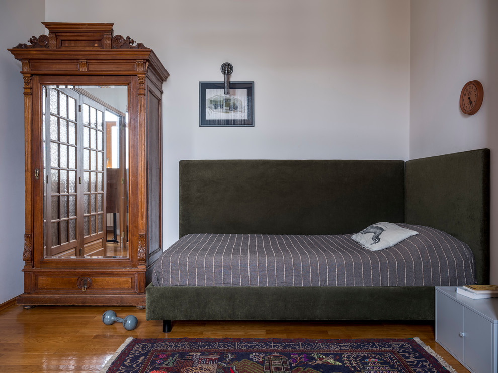 На фото: спальня в стиле ретро с белыми стенами, паркетным полом среднего тона, коричневым полом и кроватью в нише