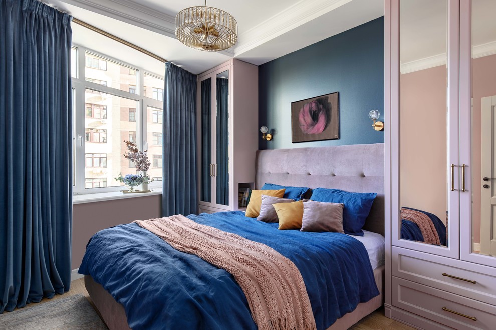 Modelo de dormitorio principal tradicional renovado pequeño con paredes azules, suelo de madera en tonos medios y suelo marrón