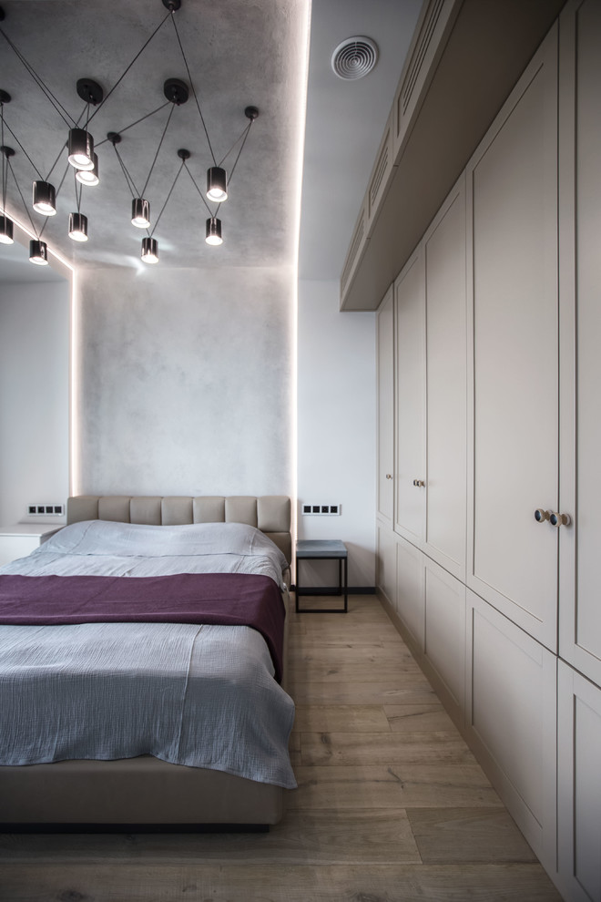 Ejemplo de dormitorio principal actual con paredes grises, suelo de madera clara y suelo beige
