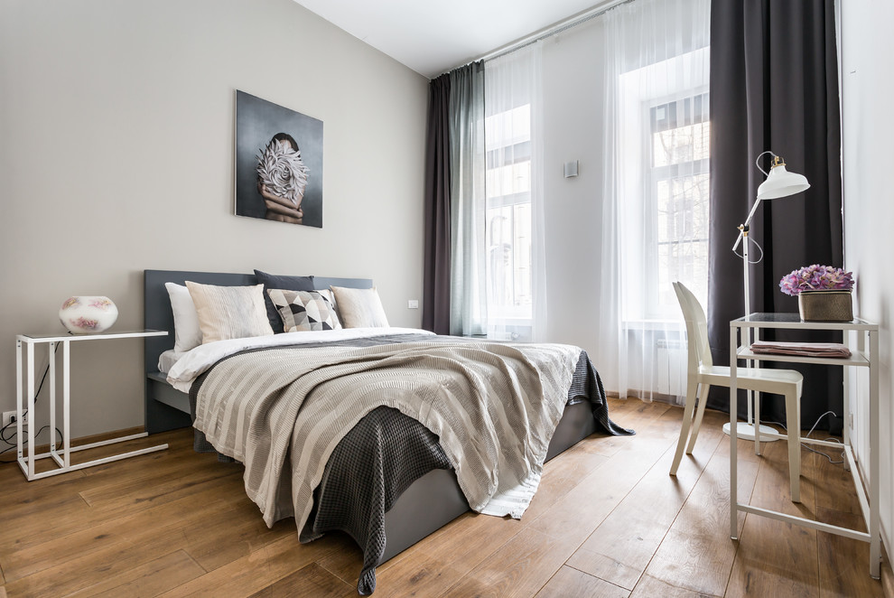 Diseño de dormitorio contemporáneo con paredes beige, suelo de madera en tonos medios y suelo marrón