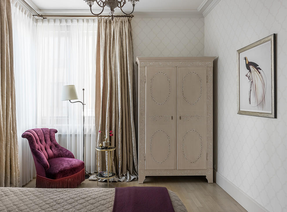 Idée de décoration pour une chambre parentale tradition de taille moyenne avec parquet clair, un sol beige et un mur blanc.