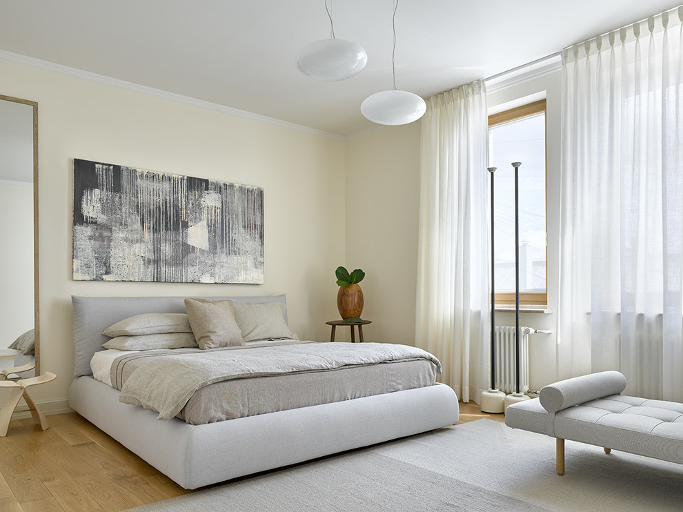 Skandinavisches Hauptschlafzimmer mit beiger Wandfarbe, braunem Holzboden und braunem Boden in Moskau