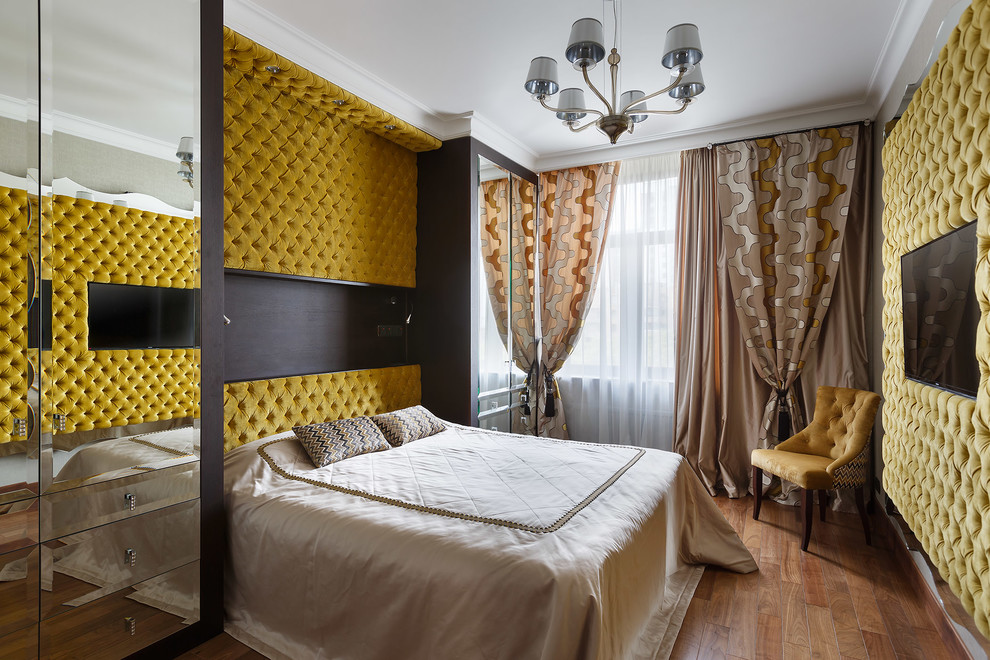Ejemplo de dormitorio principal actual de tamaño medio con suelo de madera en tonos medios y paredes amarillas