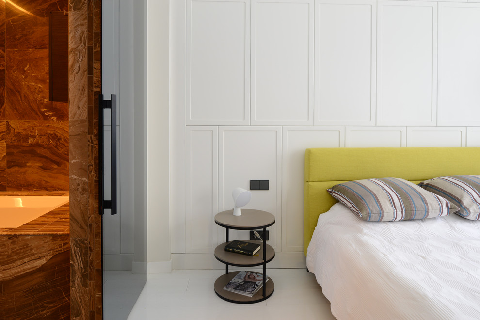 На фото: хозяйская спальня среднего размера в современном стиле с белыми стенами и деревянным полом с