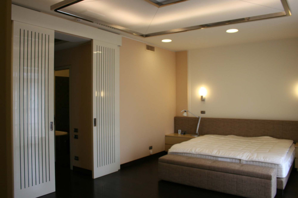Foto de dormitorio principal actual grande con paredes beige, suelo de madera oscura y suelo marrón