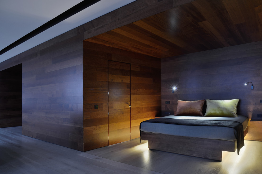 Imagen de dormitorio principal contemporáneo de tamaño medio con paredes marrones y suelo de madera en tonos medios