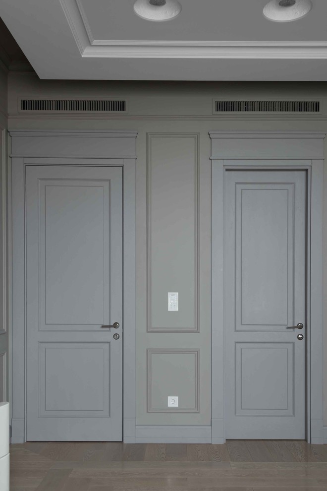 Cette photo montre une chambre tendance avec un mur gris, parquet clair et un sol beige.