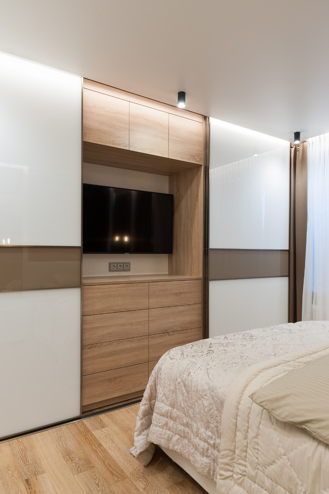 Свежая идея для дизайна: хозяйская спальня среднего размера в современном стиле с синими стенами, полом из ламината и коричневым полом - отличное фото интерьера