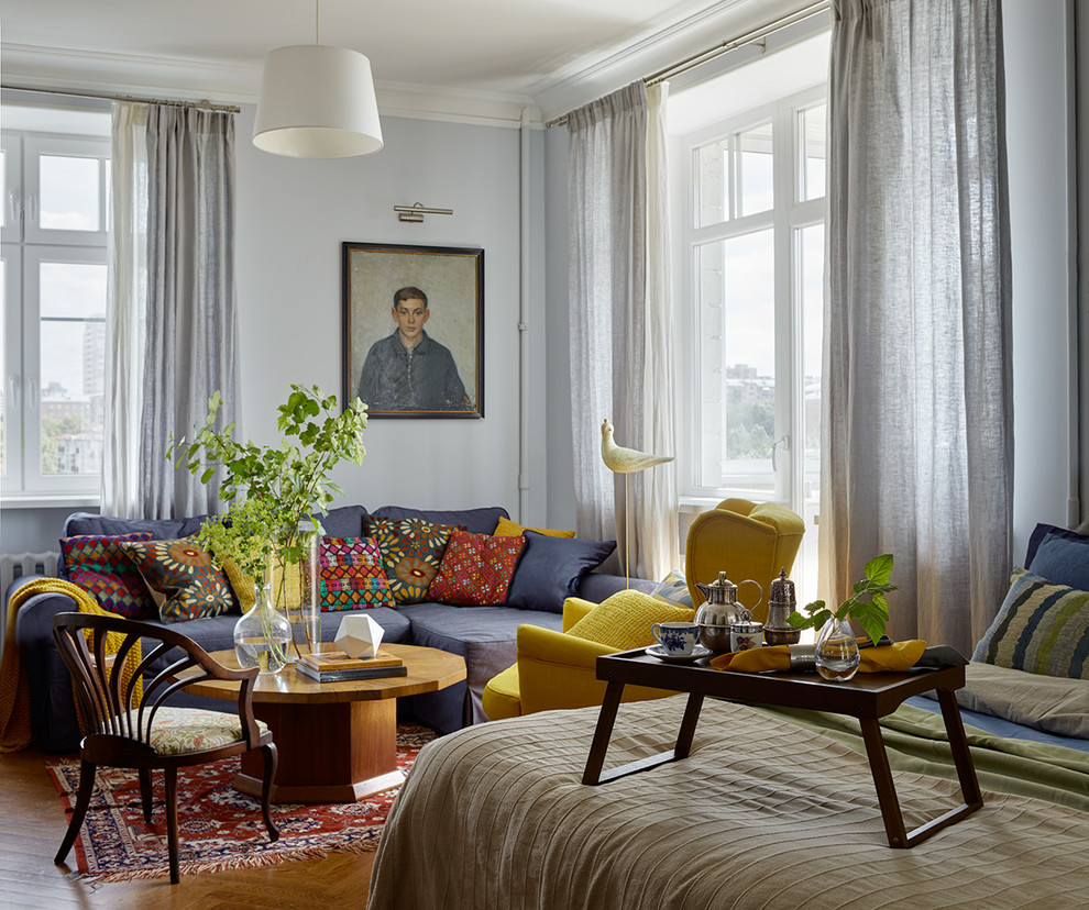 Design ideas for a medium sized eclectic enclosed living room in Moscow with medium hardwood flooring and grey walls.