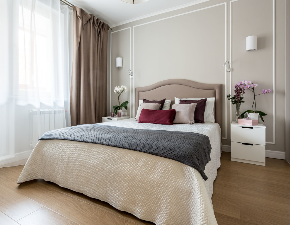 На фото: хозяйская спальня в стиле неоклассика (современная классика) с серыми стенами, паркетным полом среднего тона и коричневым полом