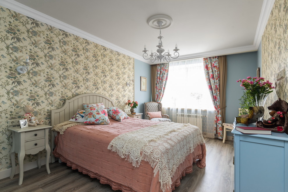 Imagen de dormitorio principal romántico con paredes azules y suelo laminado