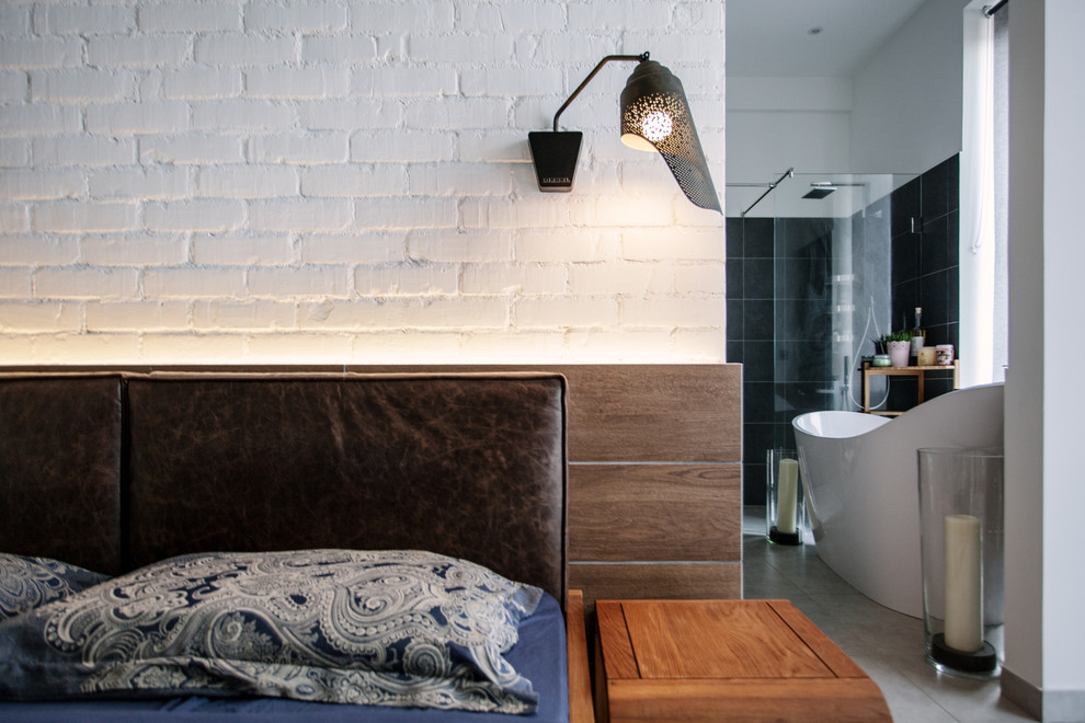 На фото: хозяйская спальня среднего размера в стиле лофт с белыми стенами, бетонным полом и серым полом с