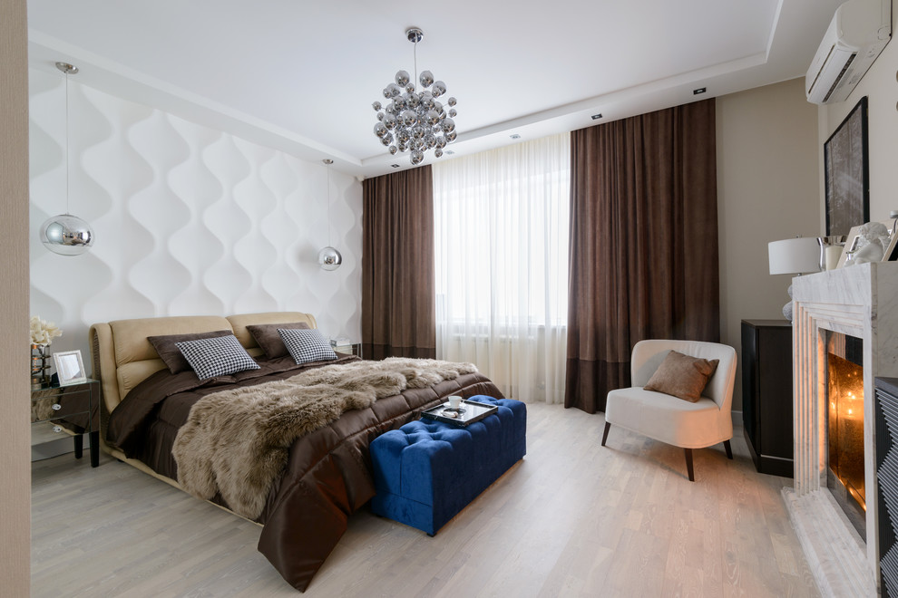 Imagen de dormitorio principal actual con paredes blancas, suelo de madera clara, todas las chimeneas y marco de chimenea de piedra