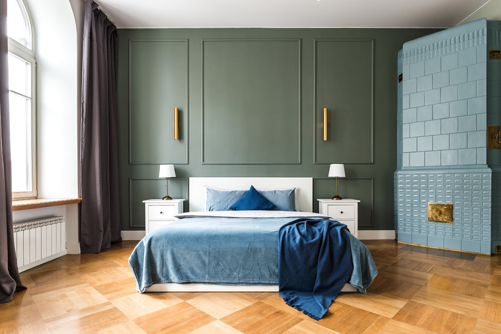 Idéer för ett modernt sovrum, med gröna väggar, mellanmörkt trägolv, en öppen hörnspis, en spiselkrans i trä och brunt golv