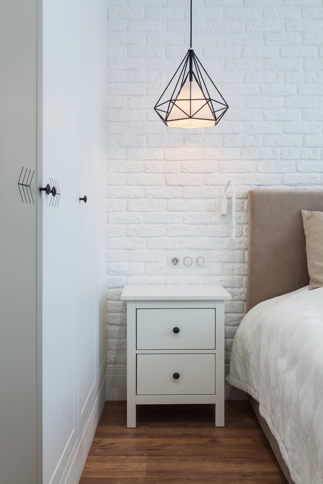 На фото: хозяйская спальня среднего размера в скандинавском стиле с белыми стенами и коричневым полом с