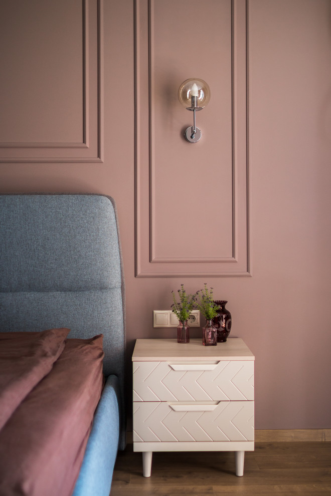 Réalisation d'une chambre parentale tradition de taille moyenne avec un mur rose, sol en stratifié et un sol marron.