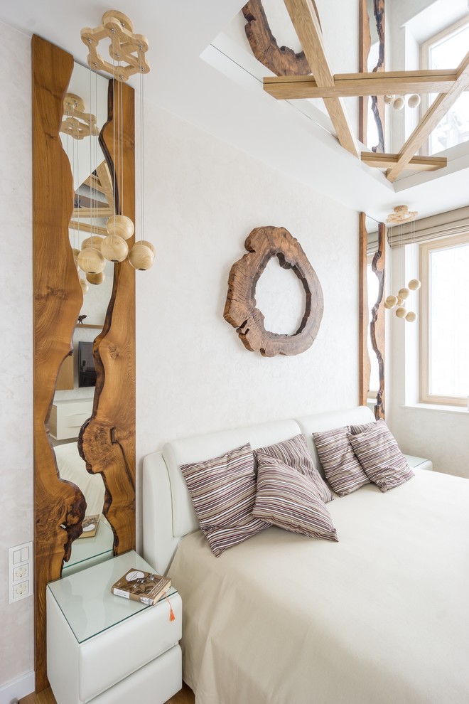 Immagine di una camera matrimoniale contemporanea di medie dimensioni con pareti bianche, pavimento in legno massello medio, nessun camino e pavimento marrone