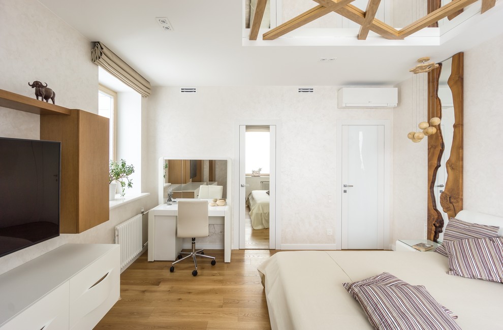 Ejemplo de dormitorio principal contemporáneo de tamaño medio sin chimenea con paredes blancas, suelo de madera en tonos medios y suelo marrón