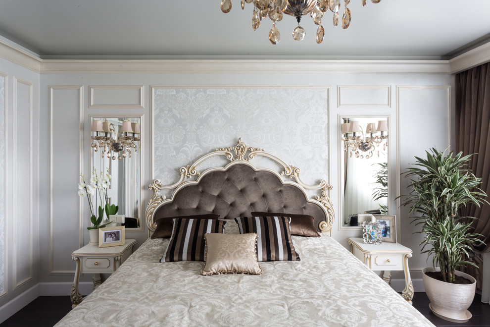 На фото: хозяйская спальня среднего размера в классическом стиле с темным паркетным полом, коричневым полом, бежевыми стенами и кроватью в нише