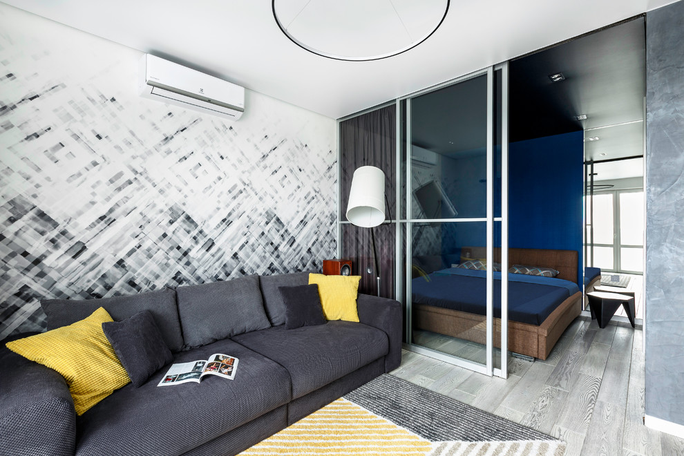 Cette image montre une chambre parentale design avec parquet clair et un sol gris.