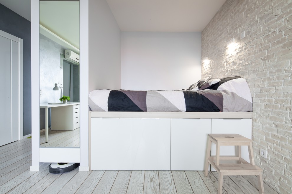 На фото: гостевая спальня (комната для гостей) в стиле лофт с белыми стенами, светлым паркетным полом и кроватью в нише