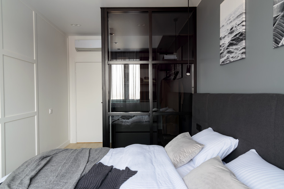 Идея дизайна: хозяйская спальня среднего размера в современном стиле с серыми стенами и полом из ламината