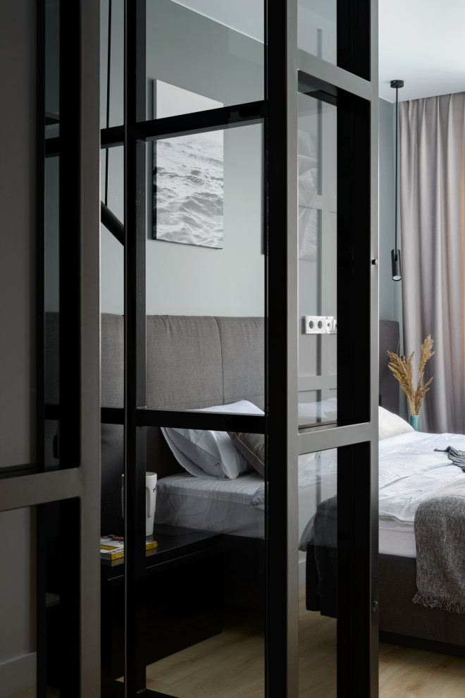 Идея дизайна: хозяйская спальня среднего размера в современном стиле с серыми стенами и полом из ламината